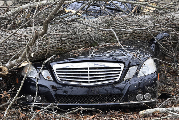 ASSOCIATED PRESS
A Mercedes-Benz parked near a home is crushed by a tree, Sunday, in Clarksville, Tenn. Tornados caused catastrophic damage in Middle Tennessee on Saturday afternoon and evening.