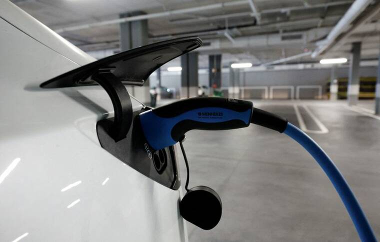 REUTERS/ALBERT GEA/FILE PHOTO
A Tesla electric vehicle is plugged into a charger in a parking lot in Teia, north of Barcelona, Spain, in October 2023.