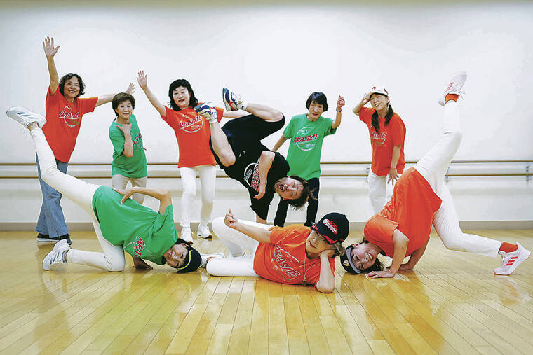 KYUNG HOON KIM / REUTERS
Members pose for a picture after a final rehearsal for a performance at a Tokyo festival. Their instructor, Yusuke Arai, 38, in the black shirt, joins them.