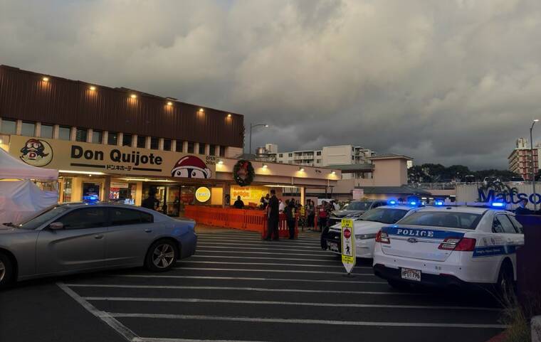 VICTORIA BUDIONO / VBUDIONO@STARADVERTISER.COM
Onlookers and police are seen outside the Don Quijote supermarket on Kaheka Street this evening as a barricade situation forced the store to close.